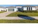 Modern home with gray siding, landscaping, and paver driveway at 9028 Ivy Stark Blvd, Wesley Chapel, FL 33545