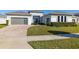 Modern house exterior with gray garage door and manicured lawn at 9028 Ivy Stark Blvd, Wesley Chapel, FL 33545