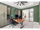 Home office with built-in green cabinets and a large desk at 9028 Ivy Stark Blvd, Wesley Chapel, FL 33545