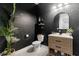 Stylish powder room featuring modern vanity and dark wallpaper at 9028 Ivy Stark Blvd, Wesley Chapel, FL 33545