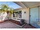 Quaint front entry with a light blue door and small garden at 9830 Mark Twain Ln, Port Richey, FL 34668