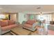 Bright living room with terracotta tile floors, featuring comfortable seating and access to the backyard at 9830 Mark Twain Ln, Port Richey, FL 34668