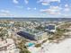 Aerial view of a condo building near beach with pool and lush landscaping at 12000 Gulf Blvd # 212-N, Treasure Island, FL 33706