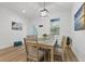 Bright dining room with a wood table, six chairs, and modern light fixture at 3471 Winona St, Port Charlotte, FL 33948