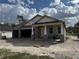 Exterior of an under construction single story home with brick and tyvek exterior and an attached garage at 413 Shannon Estates Ct, Plant City, FL 33563