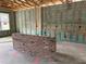 Interior view of home under construction with brick accent wall and wood framework at 413 Shannon Estates Ct, Plant City, FL 33563