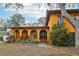 Close-up of the front of this charming yellow home with arched entry and mature landscaping at 14160 82Nd Ter, Seminole, FL 33776