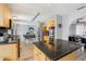 A partial kitchen view showcasing the island with black countertops and light wood cabinets at 14160 82Nd Ter, Seminole, FL 33776