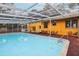 Enclosed pool area featuring seating around the pool and an eye-catching yellow house at 14160 82Nd Ter, Seminole, FL 33776