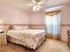 Cozy bedroom featuring carpet, floral bedding, complementary curtains, and a ceiling fan at 30923 Burleigh Dr, Wesley Chapel, FL 33543