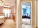 Hallway view of bedrooms featuring ceiling fans, carpets and a floral decorated bedroom at 30923 Burleigh Dr, Wesley Chapel, FL 33543