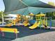 Community playground with colorful slides, climbing structures, and shaded seating at 30923 Burleigh Dr, Wesley Chapel, FL 33543