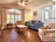 Cozy living room featuring wood floors, vaulted ceiling, a ceiling fan, and large windows at 30923 Burleigh Dr, Wesley Chapel, FL 33543