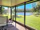 Enclosed patio with brick floors overlooks a green lawn and pond through large glass panels at 30923 Burleigh Dr, Wesley Chapel, FL 33543