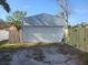 Single car detached garage with white door and wood fence at 920 Hull S St, Gulfport, FL 33707