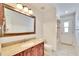 Bathroom featuring wood cabinet, granite countertop, large mirror, and tiled flooring at 12006 Stone Crossing Circle, Tampa, FL 33635