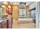 Elegant bathroom featuring a soaking tub, glass-enclosed shower, and granite countertop vanity at 12006 Stone Crossing Circle, Tampa, FL 33635