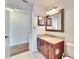 Cozy bathroom featuring wood cabinet, granite countertop, large mirror, and tiled flooring at 12006 Stone Crossing Circle, Tampa, FL 33635