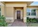 Close-up of the front entrance with a stylish wood door, brick walkway, and manicured shrubs at 12006 Stone Crossing Circle, Tampa, FL 33635