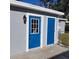 Gray shed with two blue doors, one with glass panes at 13625 120Th St, Largo, FL 33778