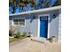 Front entrance of a light blue house featuring a bright blue door and stylish planters at 13625 120Th St, Largo, FL 33778