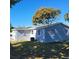 Newly painted light blue house with a blue door, landscaping, and a spacious yard at 13625 120Th St, Largo, FL 33778