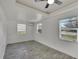 Bright bedroom with tray ceiling, tile floors, and three windows providing natural light at 5028 School Rd, Land O Lakes, FL 34638