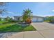 Charming single-story home boasts a two-car garage, landscaped front yard with a palm tree, and a concrete driveway at 5440 Sandy Shell Dr, Apollo Beach, FL 33572