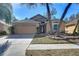 Tan one-story house with a two-car garage and mature landscaping at 2529 Clareside Dr, Valrico, FL 33596
