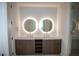 Double vanity bathroom with illuminated mirrors and wood cabinets at 777 3Rd N Ave # 1605, St Petersburg, FL 33701