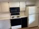 White kitchen with microwave, stove, and refrigerator at 208 Nina Way # 208, Oldsmar, FL 34677