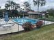 Community pool with lounge chairs and umbrellas at 208 Nina Way # 208, Oldsmar, FL 34677