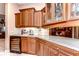 Wet bar with granite countertop and wooden cabinetry, wine cooler at 20953 Broadwater Dr, Land O Lakes, FL 34638