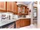 Wet bar with granite countertop and wooden cabinetry, wine cooler at 20953 Broadwater Dr, Land O Lakes, FL 34638