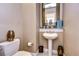 Small powder room with pedestal sink, toilet, and decorative accents at 20953 Broadwater Dr, Land O Lakes, FL 34638