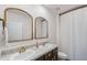 Bright bathroom featuring double sinks, decorative gold-trimmed mirrors, and a shower with a white patterned curtain at 5808 Calla Lilly Dr, Sarasota, FL 34232