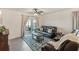 Inviting living room features a sliding door to the patio, a ceiling fan, and comfortable dark leather furniture at 5808 Calla Lilly Dr, Sarasota, FL 34232
