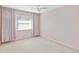 Light pink bedroom with carpet, window, and ceiling fan at 7853 Sundown Dr, St Petersburg, FL 33709