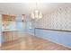 Spacious dining area with hardwood floors, floral wallpaper, and a crystal chandelier at 7853 Sundown Dr, St Petersburg, FL 33709