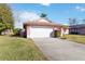 Pink house with a white garage door and a green lawn at 7853 Sundown Dr, St Petersburg, FL 33709