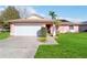Pink house with a white garage door and a well-maintained lawn at 7853 Sundown Dr, St Petersburg, FL 33709