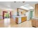 Kitchen boasts wood cabinets, an island, and a view into the dining room at 7853 Sundown Dr, St Petersburg, FL 33709