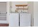 Exterior laundry room with washer, dryer, and overhead shelving at 7853 Sundown Dr, St Petersburg, FL 33709
