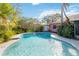 Inviting kidney-shaped pool with blue tile accents, surrounded by lush landscaping at 7853 Sundown Dr, St Petersburg, FL 33709