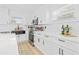 Modern white kitchen with black farm sink and stainless steel appliances at 4720 Ohio Ave, Tampa, FL 33616