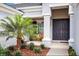 Well-maintained house with gray exterior, palm tree, and double front doors at 15304 Serengeti Blvd, Spring Hill, FL 34610
