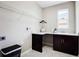 Convenient laundry room with dark cabinets and built-in shelving at 15304 Serengeti Blvd, Spring Hill, FL 34610