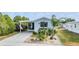 Mobile home with covered porch and nicely landscaped yard at 3836 Chris Dr, Wesley Chapel, FL 33543