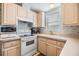 L-shaped kitchen with white appliances and light wood cabinets at 3836 Chris Dr, Wesley Chapel, FL 33543