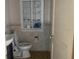Small bathroom with toilet, sink, and built-in shelving at 6658 Williams Rd, Seffner, FL 33584